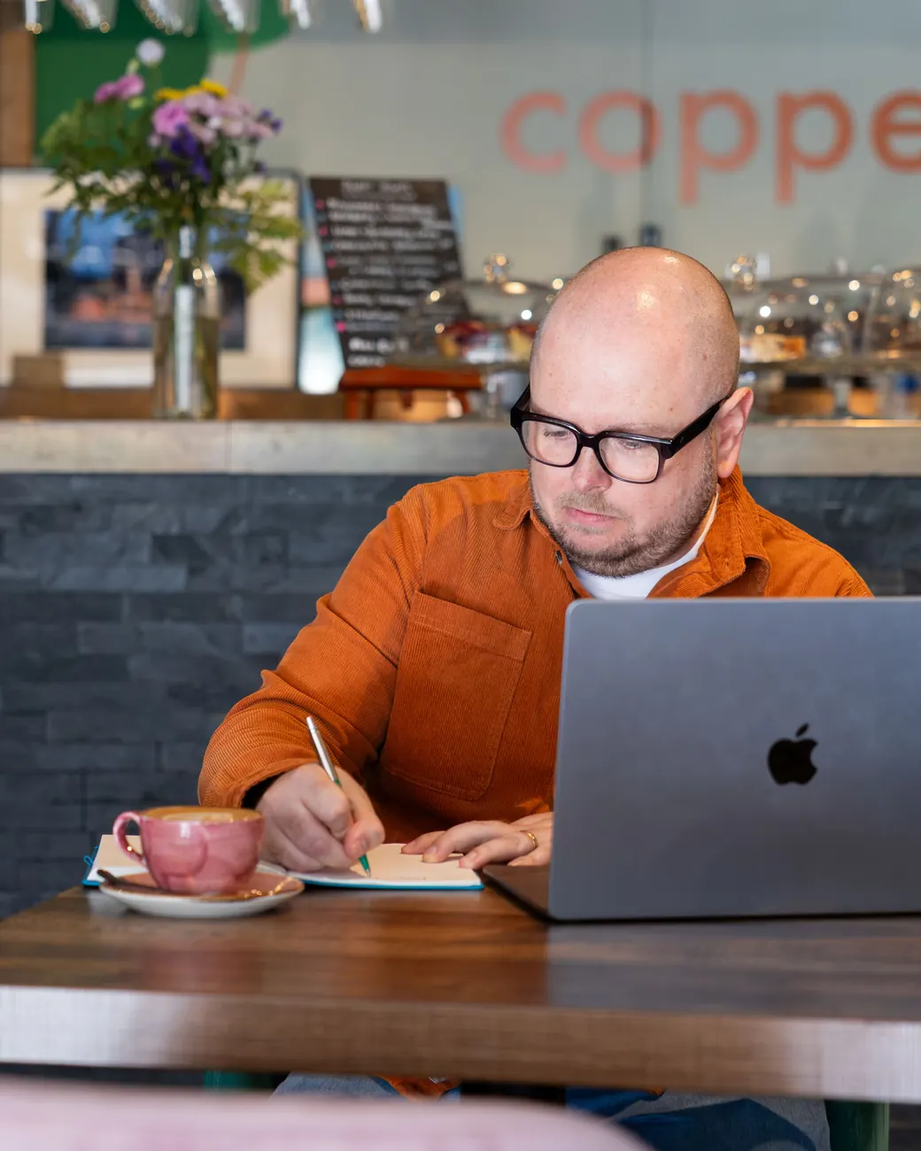 Jez Bristow working through a client's business at a cafe table